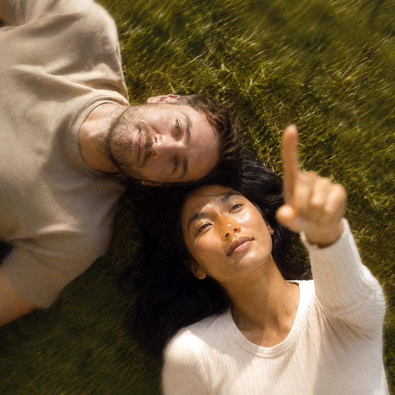 Two people lying in grass and looking upward
