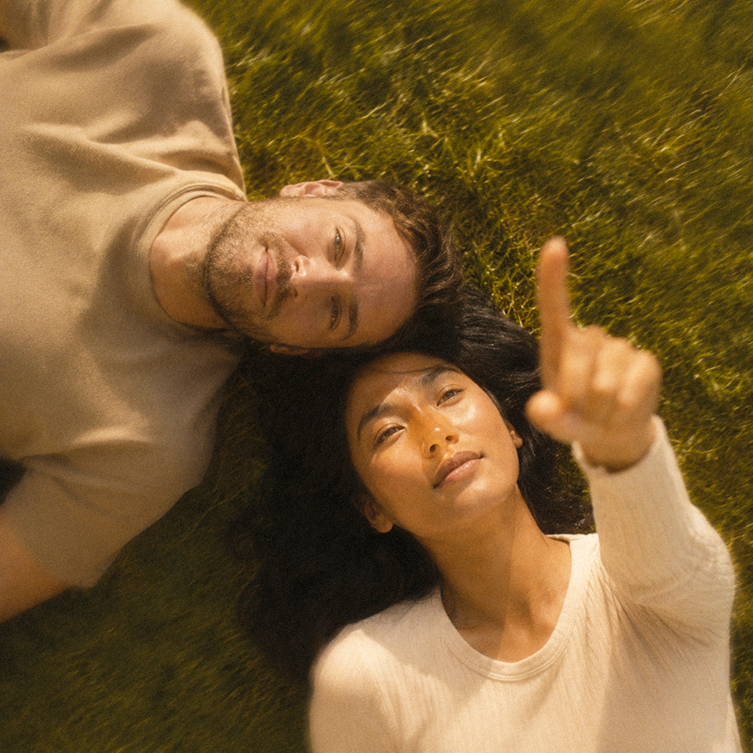Two people lying in grass and looking upward